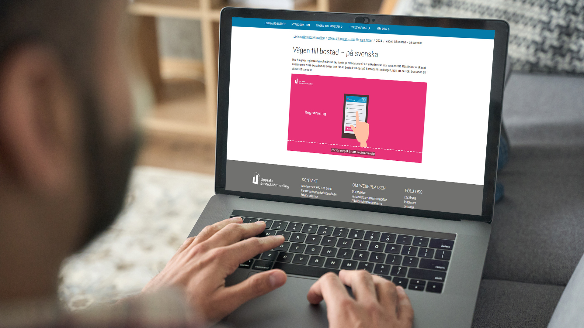 Händer skriver på laptop med webbplats om bostadskö på skärmen.